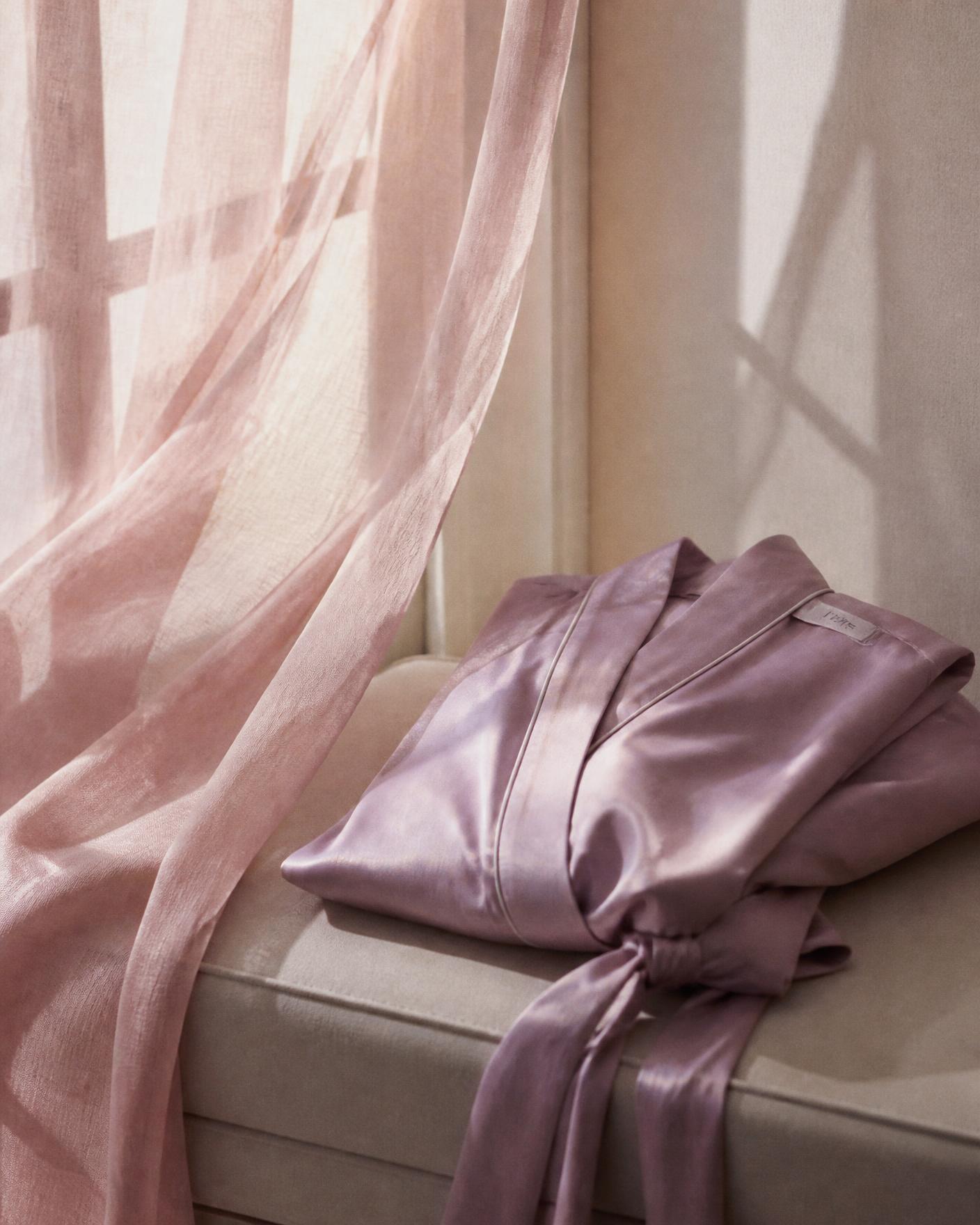 Blush sheer curtain beside a folded lavender silk robe in morning light